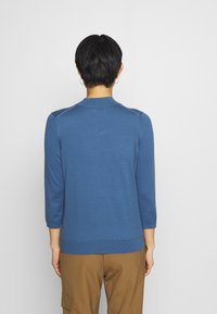 Niebieski sweter dzianinowy z rękawami 3/4, okrągłym dekoltem i ribbowanym wykończeniem. Gładka faktura, dopasowany krój, bez widocznych wzorów czy akcentów.