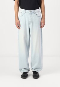 Light blue denim jeans with a loose, wide-leg fit, featuring a button closure, five pockets, and a slight fade in color.