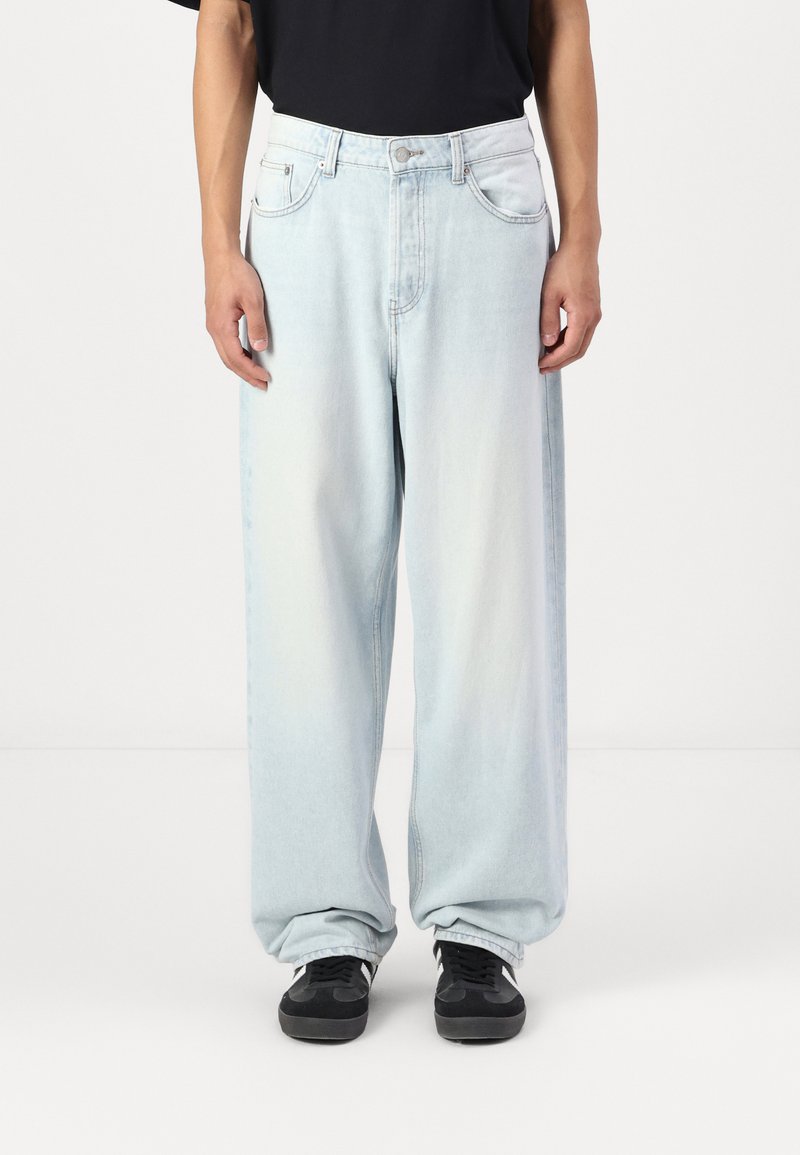 Light blue denim jeans with a loose, wide-leg fit, featuring a button closure, five pockets, and a slight fade in color.
