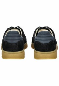Schwarze Wildledersneaker mit einer strukturierten Gummisohle. Gepolsterte graue Akzente an der Ferse. Schnürdesign mit kontrastierenden Farben und Materialien.