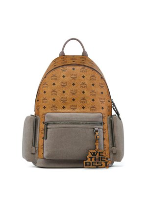 Beige-grauer Rucksack mit MCM-Logomuster, Front- und Seitentaschen mit Reißverschluss und einem Schlüsselanhänger mit der Aufschrift "WE THE BEST."