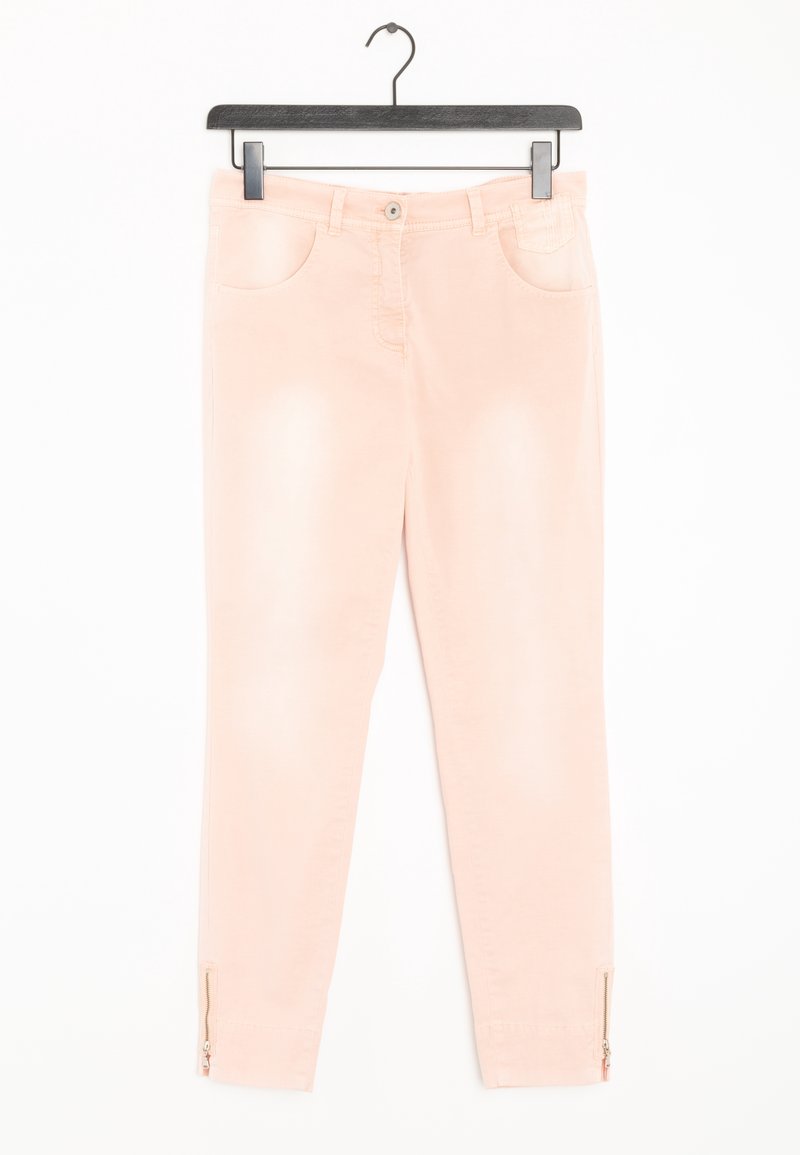 Pantalon rose clair coupe slim avec poches avant et fermetures éclair aux chevilles, suspendu à un cintre noir sur fond blanc.