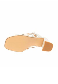Sandalo con tacco beige dal design a strappi incrociati, con tomaia in similpelle liscia e suola in gomma testurizzata, caratterizzato da un leggero rialzo del tacco.