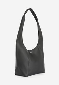 Bolso de cuero negro con un diseño curvado y relajado. Presenta una sola correa ancha para el hombro y un sutil detalle de metal.