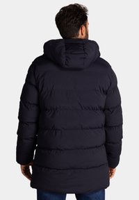 Navy pufferjack met capuchon, met horizontale quilt details, een middellange snit en een gladde, gestructureerde stof. Eenvoudig ontwerp, geen zichtbare hardware.
