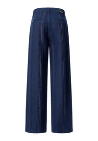 Tumedast sinisest denim kangast laiad püksid vertikaalsete triipudega. Omab kahte tagumist taskut ja nähtavat brändi sildi vööl.