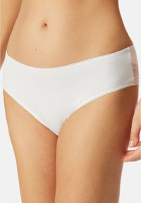 Weiße Baumwollunterhose mit Spitze am Bund. Hat eine glatte Textur und einen klassischen Schnitt. Zarte gewellte Kante am Bund.