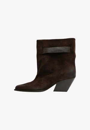 Stivale alla caviglia in suede marrone con punta affusolata, una fascia in pelle lucida testurizzata e un design con tacco chunky. Suola piatta per stabilità.