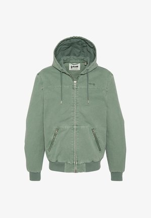 Zielona bluza z kapturem na suwak z troczkami, ściągaczami na mankietach i u dołu, dwoma przednimi kieszeniami na suwak oraz widoczną metką marki wewnątrz kołnierza.