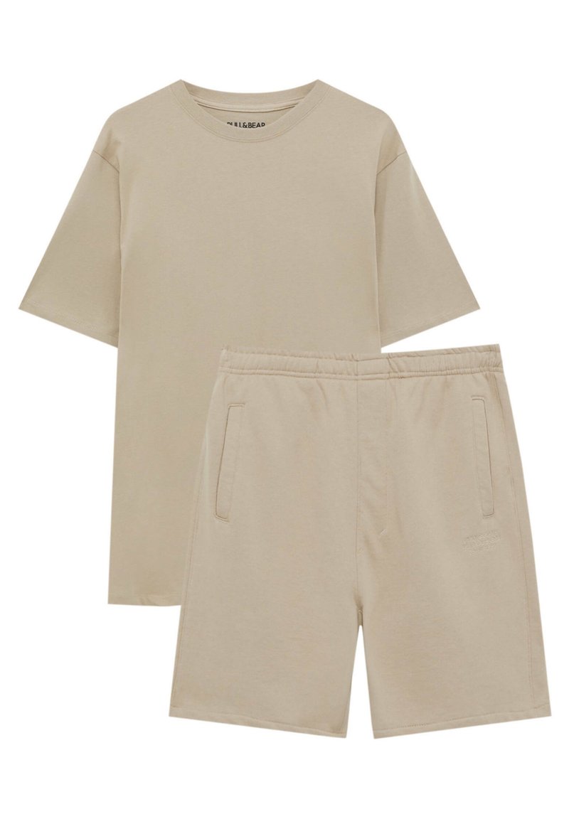 T-shirt beige à manches courtes avec col rond, associé à un short beige assorti à taille élastique et poches latérales.