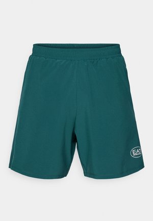 Teal athletic shorts with an elastic waistband, featuring a small white logo on the lower right. Smooth, lightweight fabric, knee-length design.