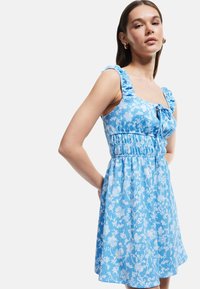 Blauw bloemenprint jurk met een vierkante halslijn, gerimpelde schouderbandjes, elastische taille en vloeiende rok. Gemaakt van lichte, gestructureerde stof.
