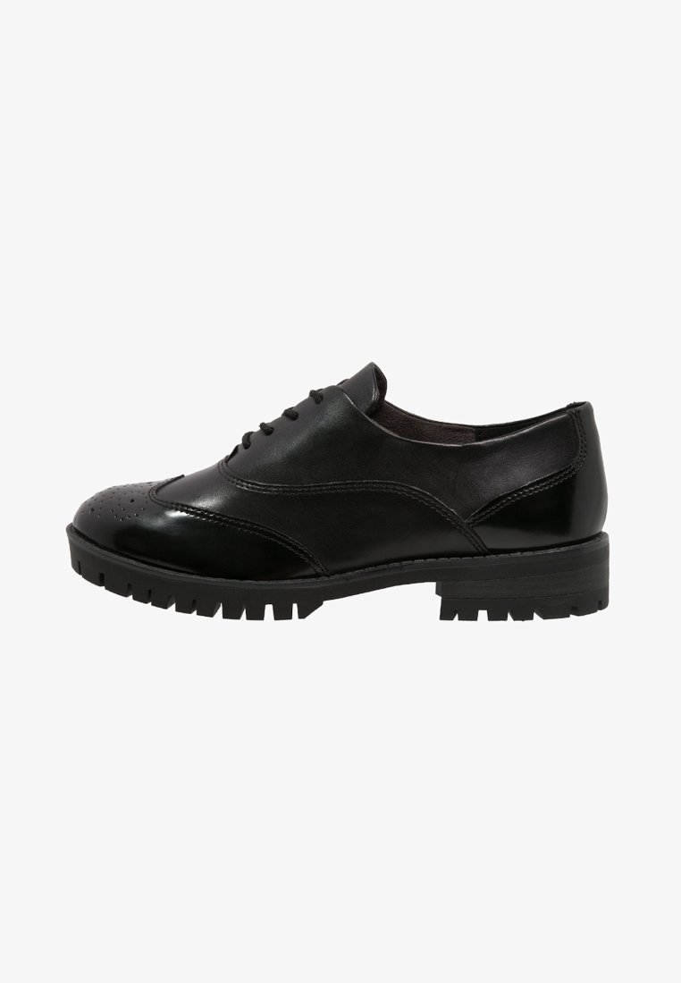 Chaussure Oxford en cuir noir avec perforations brogue, fermeture à lacets et semelle épaisse profilée, vue de côté.