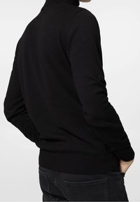 Pull-over en maille noire avec col montant, poignets et ourlet côtelés. Présente une texture lisse et une coupe ajustée avec des coutures minimales.