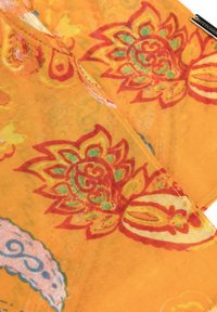 Écharpe orange ornée de motifs floraux dans des teintes rouges et vertes. Tissu léger et transparent avec des bords délicats et un design vibrant tout au long.
