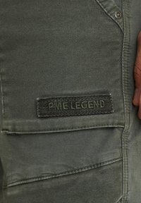 Grüne Cargo-Hose aus strukturiertem Stoff, mit auffälligen Taschen und einem gestickten "PME LEGEND"-Label in Dunkelgrün.