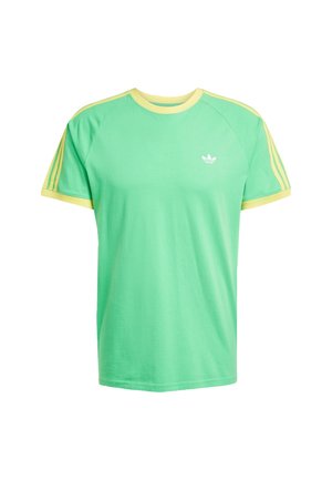 Zielona bawełniana koszulka t-shirt z żółtymi akcentami i prążkowanym kołnierzykiem. Posiada trzy żółte paski na każdym ramieniu oraz białe logo na klatce piersiowej.