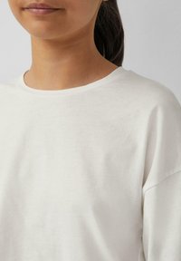 Witte katoenen t-shirt met een ronde halslijn en korte mouwen. De stof is glad, met een ontspannen pasvorm en minimale ontwerpelementen.