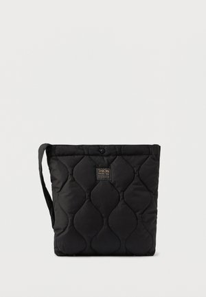 Borsa a tracolla nera trapuntata con una texture morbida, dotata di una tracolla e di una chiusura a bottone. L'etichetta del marchio è sulla parte anteriore.