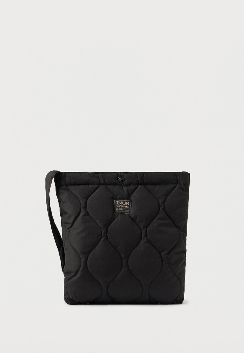 Saco tote preto acolchoado com uma textura suave, apresentando uma alça de ombro e um fecho de botão. A etiqueta da marca está na parte da frente.