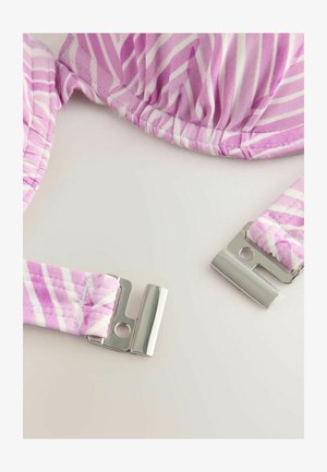 Roze i bijeli prugasti grudnjak od teksturirane tkanine, s podesivim trakama i metalnim kopčama sa svake strane.