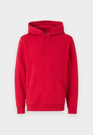 Sarkans kapuci džemperis, izgatavots no kokvilnas, ar kangaroo kabatu, regulējamu kapuci un nelielu logotipu uz krūtīm. Iezīmes ribotās aproces un apakšmalas.