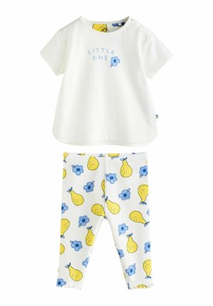 Weißes T-Shirt mit kurzen Ärmeln und dem Text „KLEINES WUNDER“ sowie einer Blumengrafik, kombiniert mit gelben Leggings mit Birnenmuster und blauen Blumen.