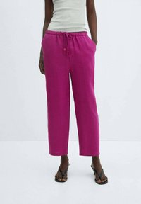 Pink linen trousers with a relaxed fit, featuring an elastic waistband and drawstring, side pockets, and a straight leg design.