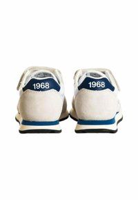 Scarpe da corsa bianche e blu navy con tacco in suede, caratterizzate dal numero "1968" in bianco sul retro e una suola in gomma nera.
