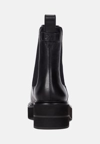 Svart läderankelboot med elastiska sidopaneler, en dragögla och en kraftig klack. Slät textur och minimalistisk design med subtila sömmar.