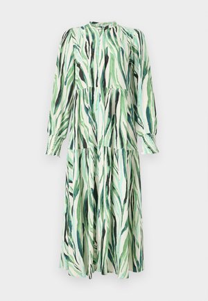 Hosszú ujjú, középhosszú ruha réteges szoknyával, zöld és fekete absztrakt levélmintával, magas nyakkal és ráncolt mandzsettákkal, fehér háttéren.