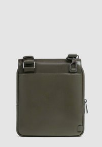 Borsa in pelle verde oliva con una texture liscia, spallacci regolabili, tasca con zip sul lato e design minimalista.