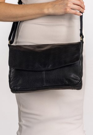 Sac à épaule en cuir noir avec un fermoir à rabat, texture lisse et une bandoulière réglable. Design simple sans accents matériels visibles.