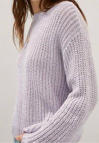 Vaaleanlaventeri neulottu neulepaita, jossa on väljä istuvuus, teksturoitu kudonta ja pitkät hihat, kuvattuna sivulta.