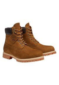 Stivaletti da lavoro in pelle marrone con lacci, colli imbottiti neri e suole in gomma robuste, con un'etichetta del logo Timberland impermeabile.