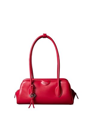 Sac à main en cuir rouge Calvin Klein avec deux longues anses, un pendentif géométrique et des fermetures éclair aux deux extrémités.
