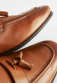 Chaussures en cuir marron avec un panneau tissé texturé, présentant une accent en lacets et une finition lisse. Bout arrondi, semelle en caoutchouc basse.