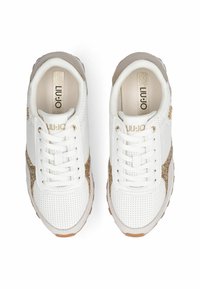 Baskets blanches avec une tige texturée, des accents dorés sur les côtés et des lacets ronds. La semelle est de couleur beige clair avec un motif antid érapant.