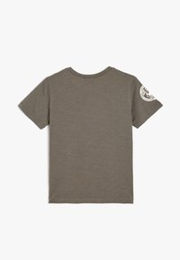 Camiseta de manga corta verde oliva hecha de tela suave, con cuello redondo y un logo gráfico blanco en la manga izquierda.