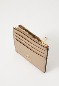 Card holder din piele bej, cu închidere cu fermoar auriu, multiple sloturi pentru carduri și detaliu cu logo embossat. Textură netedă, formă rectangulară compactă.