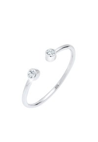Anillo abierto de plata esterlina con dos piedras redondas de circonita cúbica clara en los extremos, con una superficie lisa y pulida y un diseño minimalista.