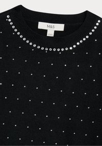 Pull noir à col rond, orné de strass argentés disposés en motif de points. Tissu doux et texturé. Étiquette visible.