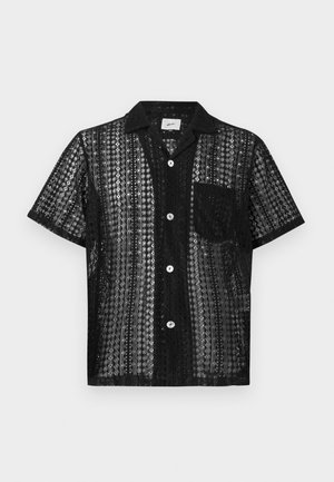 Camisa de manga corta negra con una textura semitransparente y estampada, que presenta un cuello, bolsillo frontal y cierre de botones. Diseño de rayas horizontales.