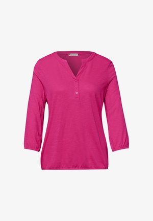 Jasnoróżowa damska bluzka z długim rękawem, z trzema guzikami na dekolcie w szpic i elastycznymi mankietami na rękawach.