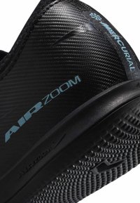 Zwarte sportschoen met een gestructureerde synthetische bovenkant, met "AIR ZOOM" en "MERCURIAL" branding in lichtblauw. Rubberen zool met grip patroon.