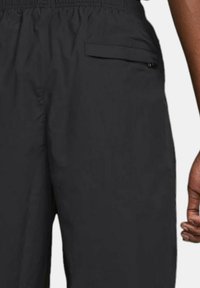 Black lightweight pants with an elastic waistband, featuring a side pocket, smooth texture, and a relaxed fit, suitable for casual wear.