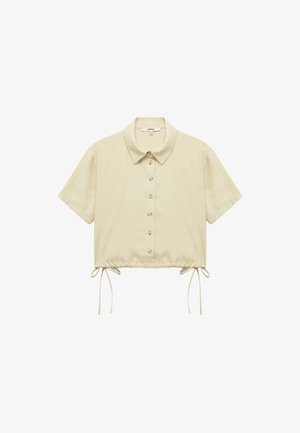 Lyhytbeige nappikauluspaita, jossa on terävä kaulus, lyhyet hihat ja säädettävät nauhat helmassa. Pehmeä, sileä kangas, jossa on yksinkertainen muotoilu.