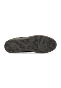 Semelle de chaussure de sport noire avec motif de grip texturé, présentant des accents circulaires et ondulés. Matériau en caoutchouc avec un dessin de bande de roulement proéminent.