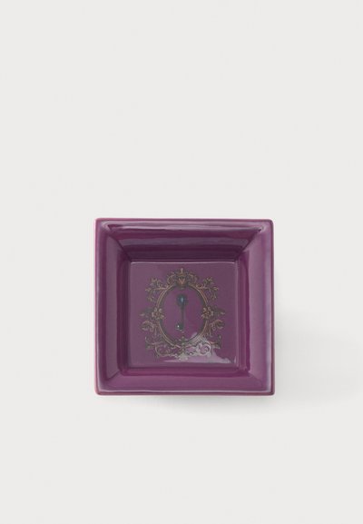 Plat carré en céramique violette avec un design de cadre orné et une petite illustration d'une clé vintage bleue au centre sur fond blanc.