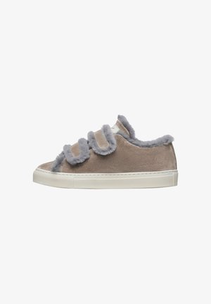 Light tan suede sneaker with grey faux fur accents and three adjustable straps. Features a white rubber sole and textured side.